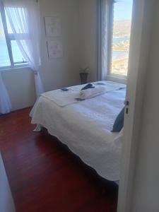 Un dormitorio con una cama blanca con una ventana. en Oasis, en Glencairn 19 fotos más
