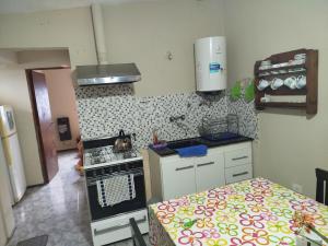 eine kleine Küche mit einem Herd und einem Bett in der Unterkunft Departamento Manna in Alta Gracia