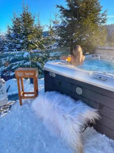 Una donna in una vasca idromassaggio nella neve di be be Chalet - premium jacuzi - 2 bedrooms a Bukovel