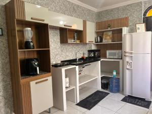 a kitchen with a white refrigerator and a counter at Condomínio Boa Ideia apart completo ao lado North Shopping Maracanaú in Maracanaú