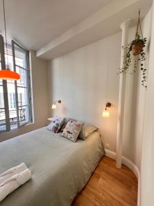 a bedroom with a bed with two pillows on it at Design et Charme en Centre Ville - 2 Chambres Doubles - Parking Public Gratuit in Avallon