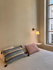 a bedroom with a bed with two pillows on it at Design et Charme en Centre Ville - 2 Chambres Doubles - Parking Public Gratuit in Avallon +9 photos