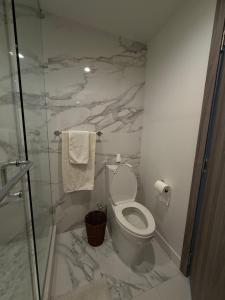 een badkamer met toilet en glazen douche bij Private Room in a Three-Bedroom Penthouse in Surrey in Surrey +1 foto