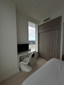 una camera da letto con un letto, una tv e una finestra di Penthouse Luxury Room in Surrey a Surrey 1 altra foto
