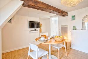 a kitchen and dining room with a table and chairs at Le Vauquelin - Hypercentre - Wifi in Caen +6 photos