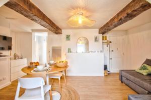 a kitchen and living room with a table and a couch at Le Vauquelin - Hypercentre - Wifi in Caen