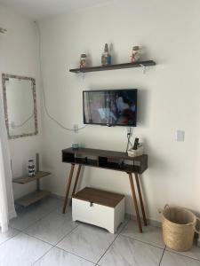 Una sala de estar con un televisor en la pared. en Relaxing House on Barra Velha Beach, en Barra Velha