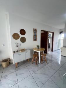 Sala de estar con mesa y 2 taburetes en Relaxing House on Barra Velha Beach, en Barra Velha