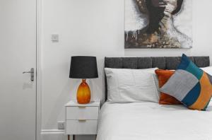 a bedroom with a bed with a lamp on a night stand at Amazing 1 Bedroom Flat in Central London in Moffat