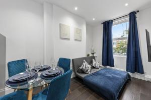 a dining room with a table and blue chairs at Amazing 1 Bedroom Flat in Central London in Moffat +8 photos