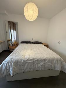 a bedroom with a bed with a white comforter at Petit House Madrid Chinatown in Madrid