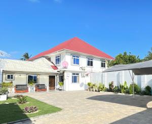 a white house with a red roof at HalmaHome in Chukwani