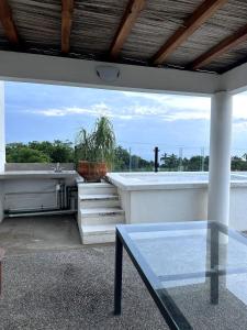 a glass table in front of a balcony with a plant at Terraza Carrizalillo in Puerto Escondido