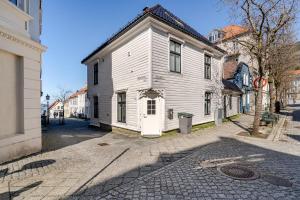 ein altes weißes Haus in einer Straße in einer Stadt in der Unterkunft Skuteviken House in Bergen
