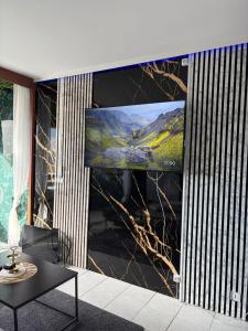 a living room with a large screen tv on a wall at L'Essentiel in Cap d'Agde
