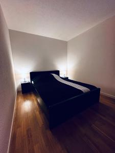 a bedroom with a bed with two lights on it at Modernes City Apartment am See, Zentral in Rorschach