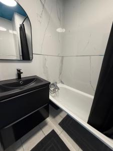 a bathroom with a sink and a tub and a mirror at L'Essentiel in Cap d'Agde +19 photos