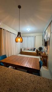 a living room with a wooden table and a couch at Apartamento - Garden Flat Mar Azul in Taíba +23 photos