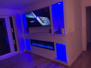 a living room with a fireplace with blue lights at Woodlands in Wythenshawe
