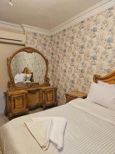 a bedroom with a large bed and a mirror at Atlantis Palace Pyramids View in ‘Ezbet `Abd el-Ḥamîd