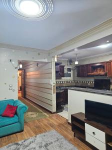 a living room with a blue couch and a kitchen at Atlantis Palace Pyramids View in ‘Ezbet `Abd el-Ḥamîd