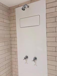 a shower with two faucets on a brick wall at Frente Mar - Beach Class Internacional - Flat Boa Viagem in Recife