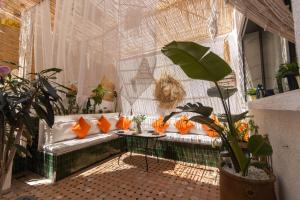 a room with a couch with orange pillows on it at Charm and Calm - Superbe appartement de luxe - Dahomy Beach - Bahia Beach in Bouznika