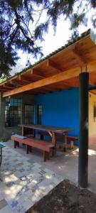 a picnic table under awning in front of a building at Quinta RASPANDO in La Reja