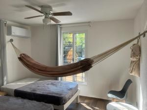 a bedroom with a hammock hanging from a ceiling at Casa SaasNá, Departamento B, C y D in Cedro