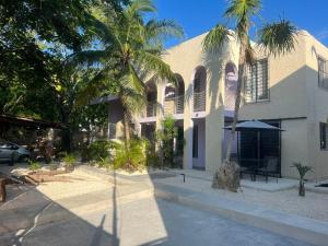 a building with palm trees in front of it at Casa SaasNá, Departamento B, C y D in Cedro