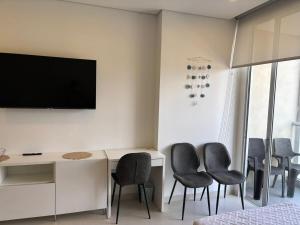 Zimmer mit einem Schreibtisch mit Stühlen und einem TV in der Unterkunft Escápate y convierte tus vacaciones en recuerdos in Santa Marta