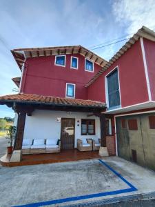 a red and white house with a driveway at Casa adosada Villa Carlota en entorno tranquilo in Reocín