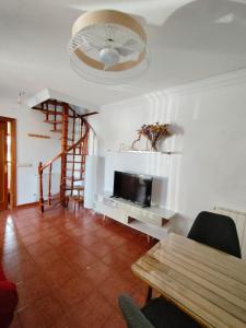 a living room with a tv and a table at Casa adosada Villa Carlota en entorno tranquilo in Reocín