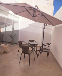 a patio with a table and chairs and an umbrella at Duplex Premium Cayma Céntrico in Cayma
