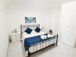 a bedroom with a bed with blue sheets and blue pillows at La Rondine B&B in Massa Lubrense