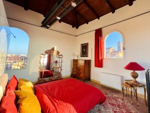 a bedroom with a red bed and two windows at Tower of Lovers - Ancient Altana in Bologna +31 photos