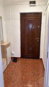 a wooden door in a room with a tile floor at Garsonieră Craiova in Craiova +1 photo