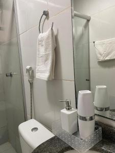 Un baño con inodoro, lavabo y espejo. en Suíte Apoena - Your place in COP 30, en Belém