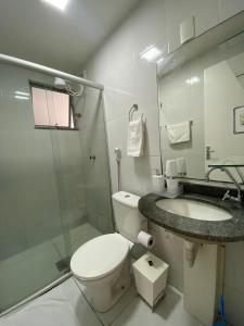 Un baño con inodoro, lavabo y ducha. en Suíte Apoena - Your place in COP 30, en Belém