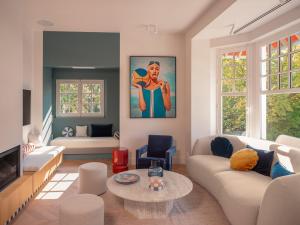 a living room with a couch and a table at Villa des Rêves - Padel, Piscine, Jacuzzi, proche Deauville in Villers-sur-Mer