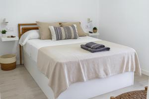 una camera da letto bianca con un letto con una coperta sopra di Playa y Comodidad en Benicàssim a Benicàssim Altre 17 foto
