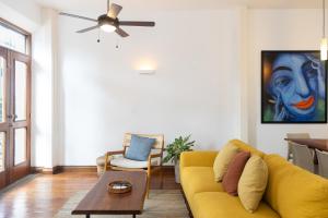 a living room with a yellow couch and a ceiling fan at Beachfront penthouse in Casco Antiguo in Punta Chame