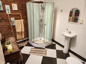 a bathroom with a glass shower and a sink at La Casa Piola in Valparaíso