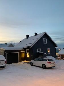 two cars parked in front of a black house at Tromsø - seksjonert hus i nydelige omgivelser in Trondalen