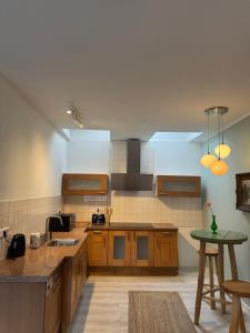 a large kitchen with wooden cabinets and a table at Beim Goldenen Dackel -Atelierhaus im Hof in Übach-Palenberg