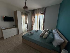 - une chambre dotée d'un lit avec des oreillers et d'une grande fenêtre dans l'établissement Home Capri, à Torre del Greco
