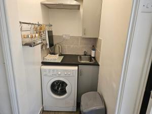 a small kitchen with a washing machine and a sink at Town Centre Studio - Sleeps 2 - Parking in Reading