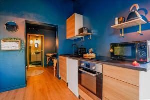 a kitchen with blue walls and a counter top at L'instant Suspendu-Studio Jacuzzi Terrasse Plages in Saint-Aunès