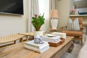 a living room with a coffee table with books on it at The Loft Apartment in Gaborone in Gaborone