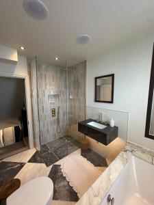 a bathroom with a shower and a sink and a tub at High spec 4 bed Victorian house in Surbiton